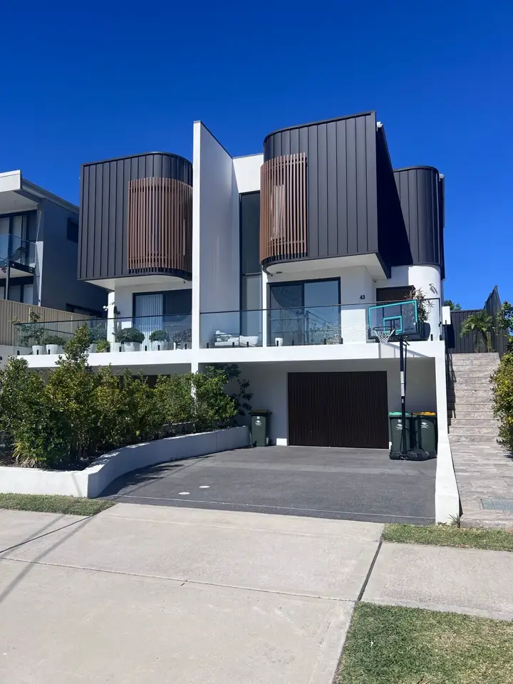 A dark and white contemporary duplex under a clear blue sky